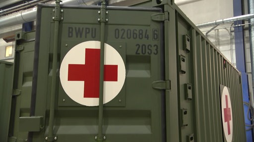 Ein Militär-Container mit einem roten Kreuz darauf.