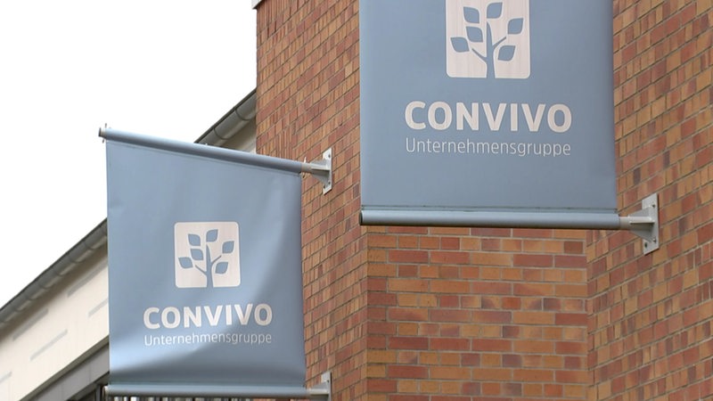 Zu sehen sind Banner der Convivo Unternehmensgruppe, welche an einer Hausfassade hängen.