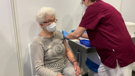 Eine Seniorin bekommt eine Impfung von einer Ärztin verabreicht.