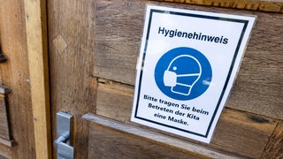 Ein Schild am Eingang einer Kita weist auf Hygieneregeln hin.