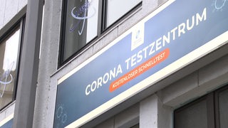 Ein "Corona Testzentrum" Schild an einer Hauswand.