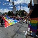 Ein Mann in Bremerhaven schwenkt eine Regenbogenflagge beim CSD