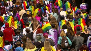 Viele Menschen mit Regenbogen-Flaggen beim CSD-Umzug in Bremerhaven.