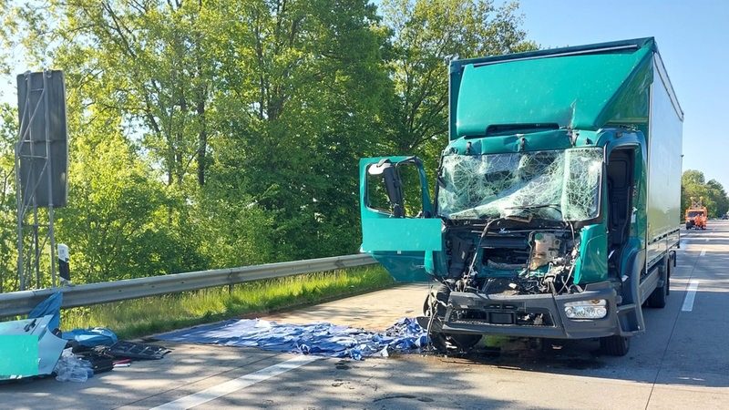 Auf einem Autobahnabschnitt steht ein nach einem Unfall demolierter Lastwagen.