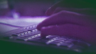Hände die auf einer Pc Tastatur tippen. 