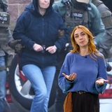 Eine junge Frau steht vor dem Bild der verhafteten Daniela Klette