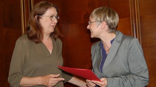 Bremens Finanzsenatorin Karoline Linnert übergibt Imke Sommer eine Ernennungsurkunde.