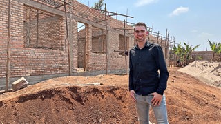Der Bremerhavener Basketballer Adrian Breitlauch vor einer Baustelle in Ruanda.