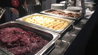 Rotkohl, Klöße und Fleisch stehen auf einem Buffet bereit.