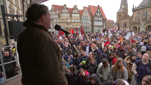 Der Sprecher des Zentralelternbeirates Martin Stoevesandt auf der Bühne bei einer Demonstration auf dem Bremer Marktplatz. 