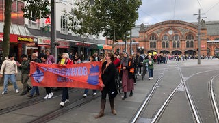 Menschen demonstrieren vor dem Bremer Hauptbahnhof.