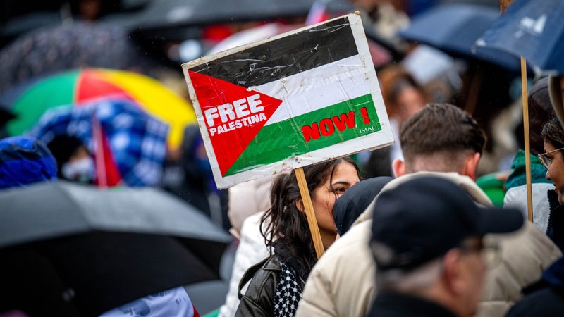 Teilnehmerinnen und Teilnehmer an der Pro-Palästina-Kundgebung der Palästinensischen Gemeinde Bremen stehen auf dem Platz der Deutschen Einheit vor dem Hauptbahnhof.
