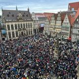 Menschenmenge auf dem Bremer Marktplatz, in der Mitte der Roland. 