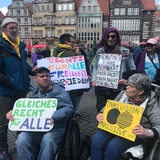 Mehrere Menschen mit Schildern demonstrieren vor der Bremischen Bürgerschaft ür Gleichberehctigung.
