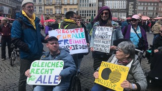 Mehrere Menschen mit Schildern demonstrieren vor der Bremischen Bürgerschaft ür Gleichberehctigung.
