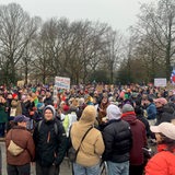 Eine Menschenmenge steht auf einer Straße.