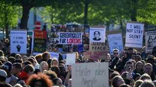 Demonstranten halten Schilder hoch