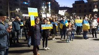 Menschen mit ukrainischen Flaggen vor dem Bremer Hauptbahnhof