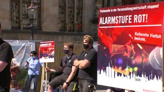 Ein rotes Schild auf einer Demonstration der Veranstaltungswirtschaft: "Alarmstufe Rot"!