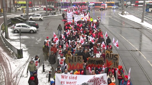 Ein Demonstrationszug der Gewerkschaft GEW, es werden Plakate und Fahnen hochgehalten.