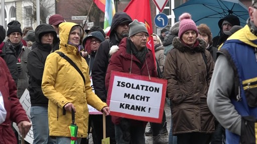 Teilnehmer der Demonstration gegen die Corona-Maßnahmen mit einem Schild auf dem " Isolation macht Krank" steht, in Rotenburg.
