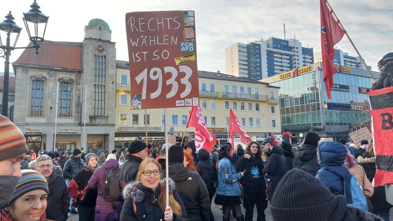 Eine Frau hält bei einer Demo ein Plakat "Rechts wählen ist so 1993" in die Luft