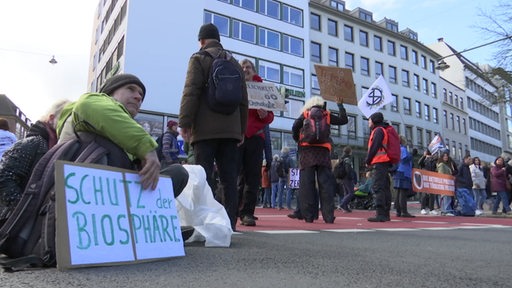 Demonstrierende der "Letzten Generation" blockieren eine Kreuzung in der Bremer Innenstadt.
