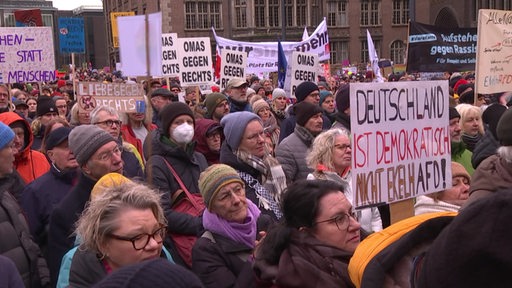 Viele Menschen demonstrieren gemeinsam auf der Straße in Bremen. 
