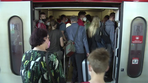 Viele Fahrgäste drängen sich beim Einstieg eng an eng in einen Zug der Deutschen Bahn im Bremer Hauptbahnhof.