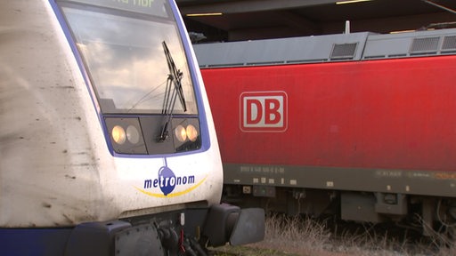 Es ist ein Wagon der Deutschen Bahn und eine Lok von Metronom im Bremer Bahnhof zu sehen.
