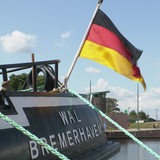 Eine Deutschland-Fahne, die an einem Schiff hängt.