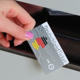 Eine Hand hält das Deutschlandticket.