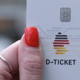 Eine Person hält ein Deutschlandticket in der Hand