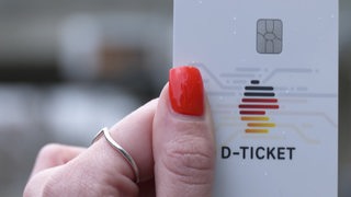 Eine Person hält ein Deutschlandticket in der Hand