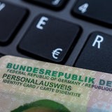 Ein Personalausweis liegt auf einer Laptoptastatur.