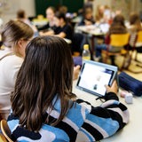 Schülerinnen arbeiten im Unterricht an iPads.