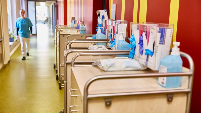 Eine Pflegerin geht den Gange eines Krankenhauses entlang.