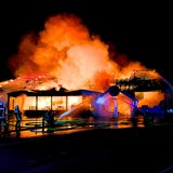 Einsatzkräfte der Feuerwehr löschen eine brennende Disco.