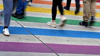Menschen auf einem Fußgängerübergang in Regenbogenfarben