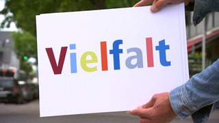 Ein weißes Blatt, wo mit bunter Schrift Vielfalt draufsteht. 