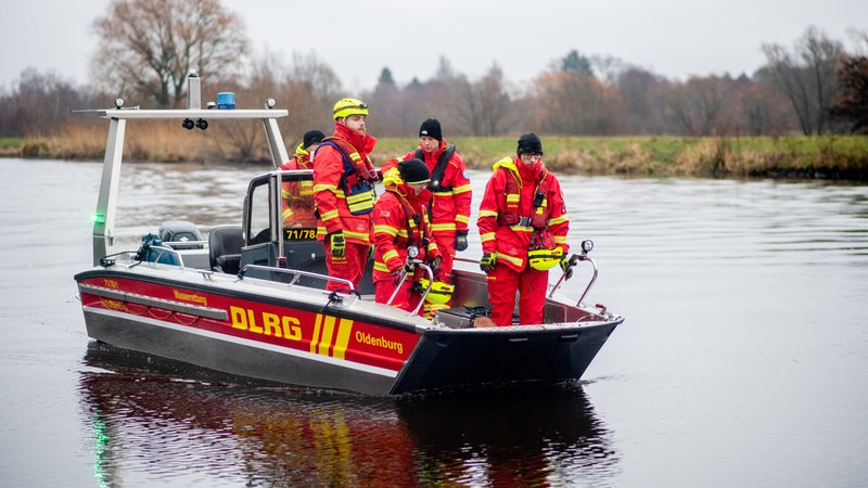 Mitglieder der DLRG stehen in einem Einsatzboot.
