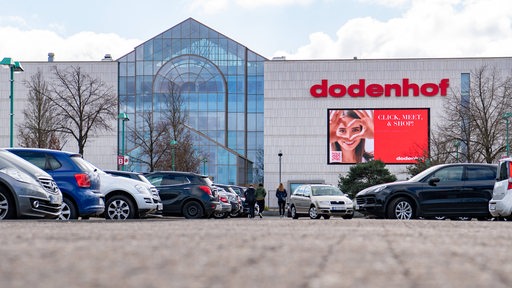 Das Einkaufszentrum Dodenhof in Posthausen mit parkenden Autos und Menschen