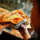 Eine Frau hält einen Döner Kebab in der Hand