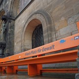 Eine Bank vor der Kirche mit der Aufschrift "kein Platz für Gewalt"