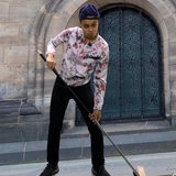 Eine Frau fegt die Treppen vor dem Bremer Dom.