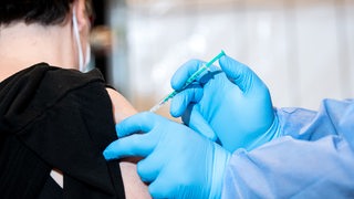 Eine Frau wird im Bremer Impfzentrum geimpft