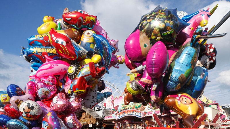 Luftballons wehen auf einem Jahrmarkt.