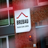 Ein Schild weist auf den Firmensitz der Wohnungsbaugesellschaft Brebau hin.