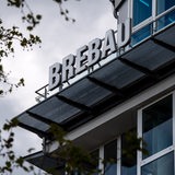 Ein Schild weist auf den Firmensitz der Wohnungsbaugesellschaft Brebau hin.