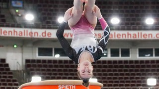 Turnerin Karina Schönmaier während einer Drehung in der Luft beim Sprungfinale.